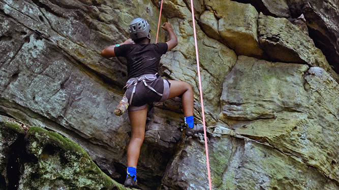 A rock climber scales a rock formation.