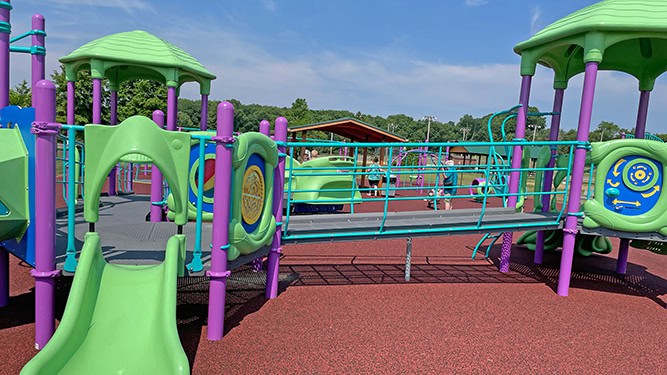 Brightly-colored playground equipment attached by wide, accessible platforms