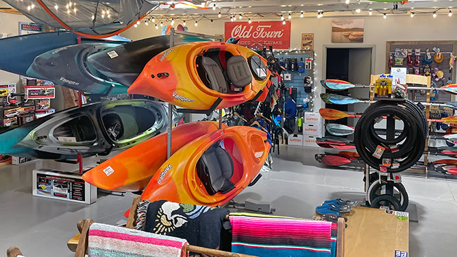 A store featuring kayaks, paddles, towels and other miscellaneous outdoor recreation items.