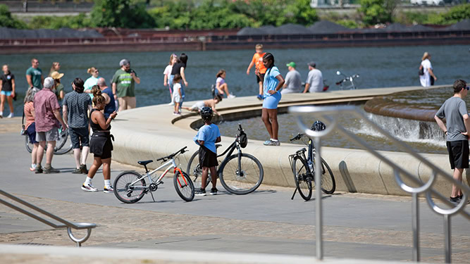 A large group of people surround the fountain at Point State Park in Pittsburgh, Pennsylvania.